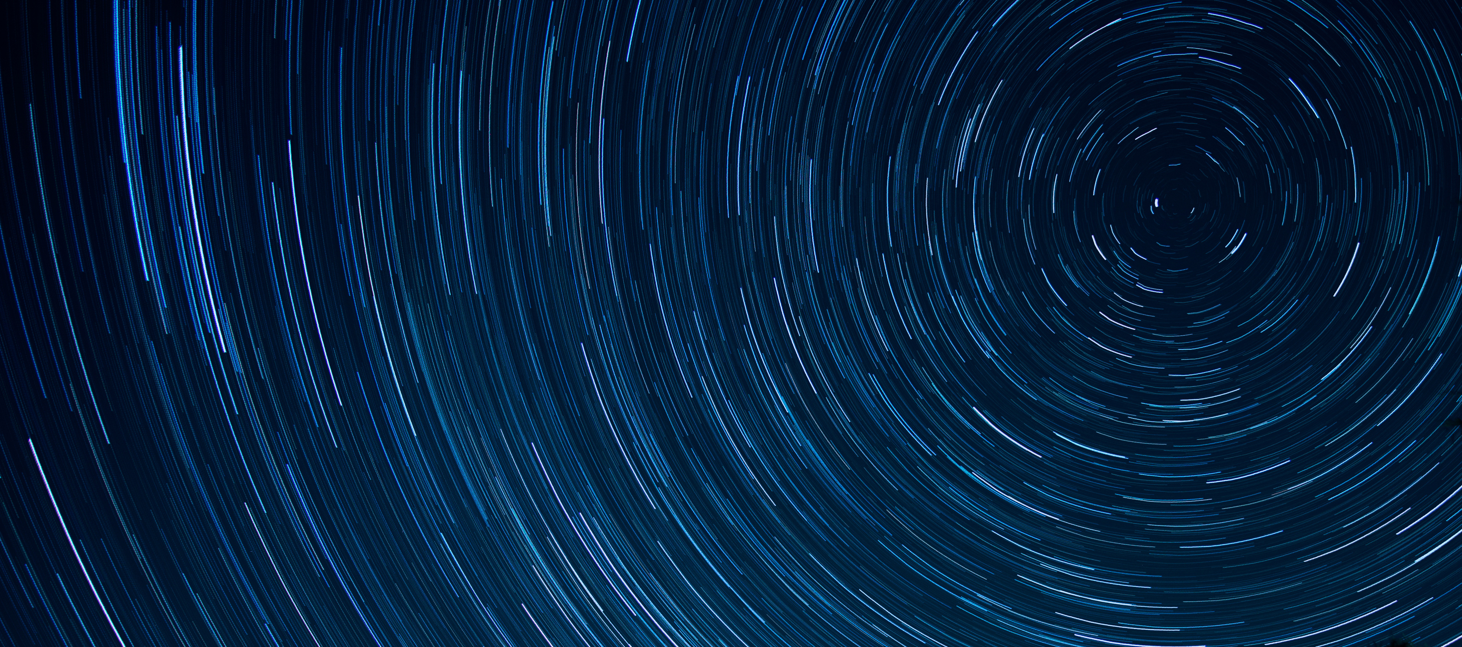 Long-exposure star trails over a construction site at night
